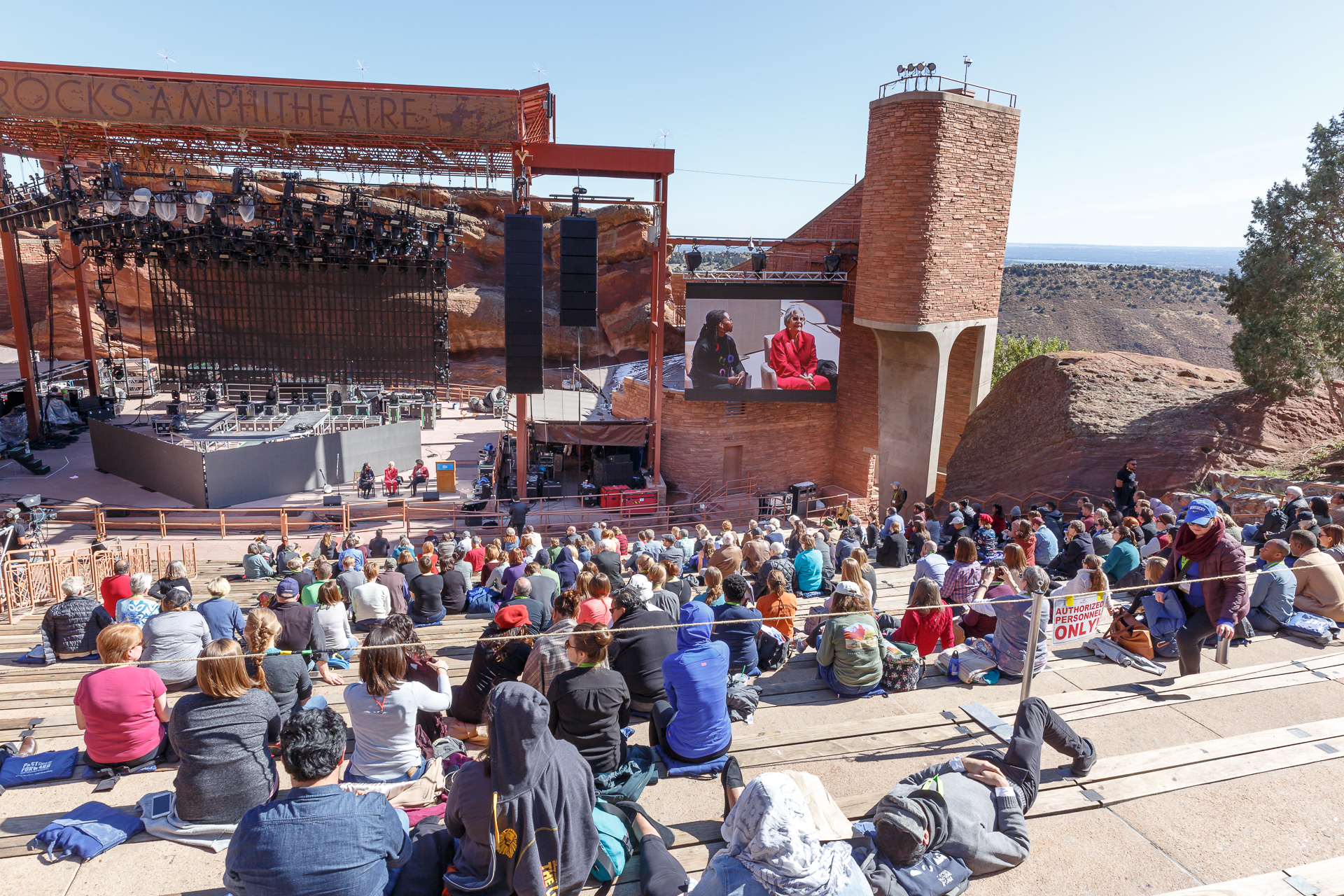 Panned out view of Red Rocks Amphitheatre with Tiya Miles, Ada Deer, and Amythyst Kiah sitting in chairs on stage at PastForward.