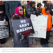 woman holds up a sign that says we can't breathe at a protest