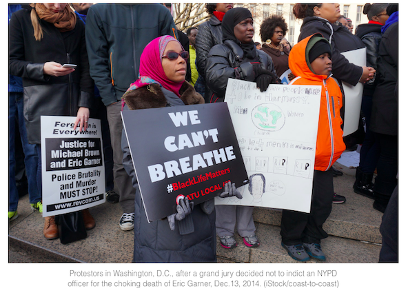 woman holds up a sign that says we can't breathe at a protest